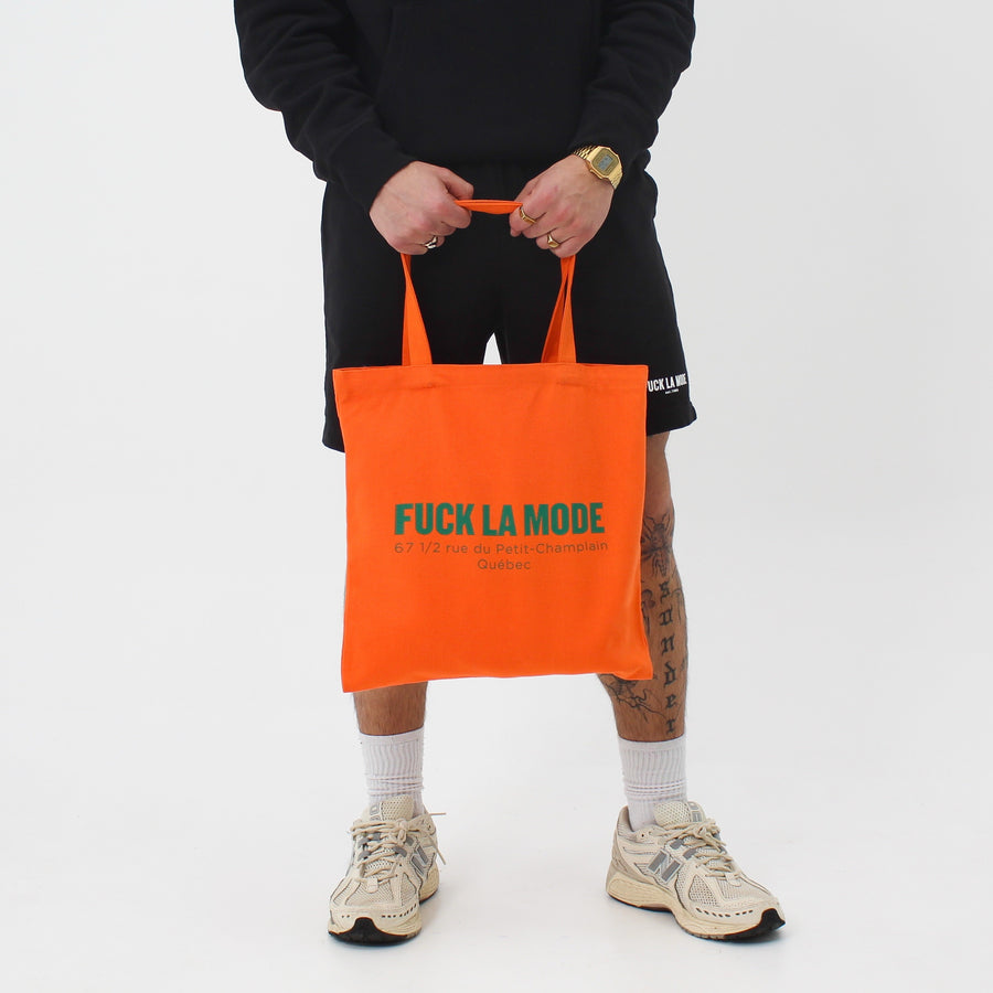 Orange Address tote bag with the “fuck la mode” logo and address in forest green — streetwear clothing from Québec City.