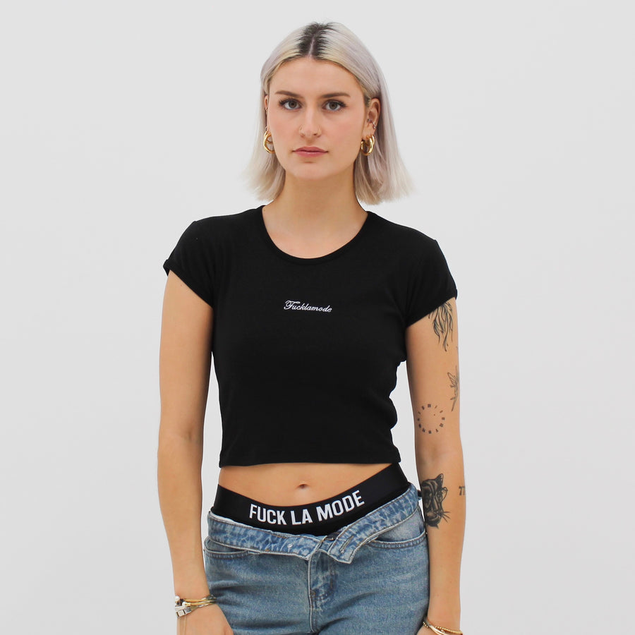 Black baby tee with the “fuck la mode” script logo on the front — streetwear clothing from Québec City.
