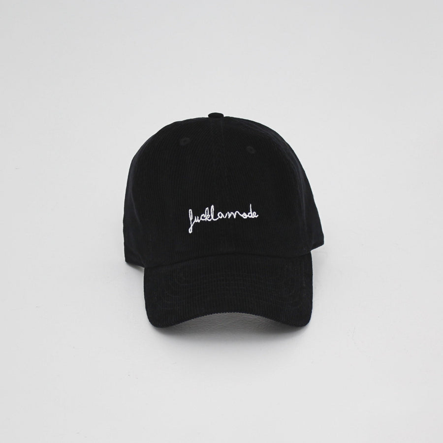 Black corduroy cap with the hand-written “fuck la mode” logo in white — streetwear clothing from Québec City.