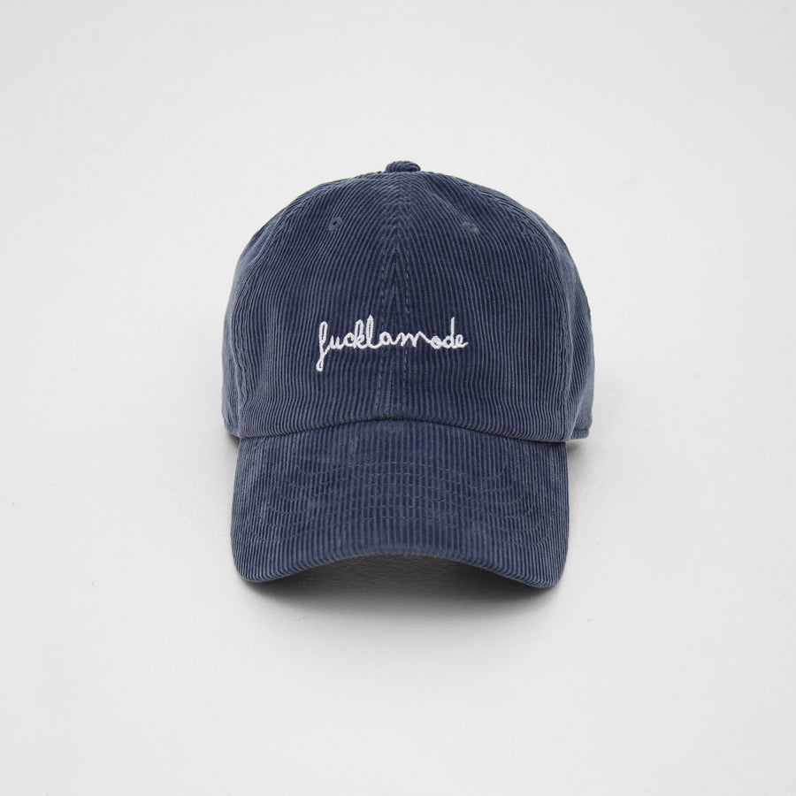 Denim blue corduroy cap with the hand-written “fuck la mode” logo in white — streetwear clothing from Québec City.