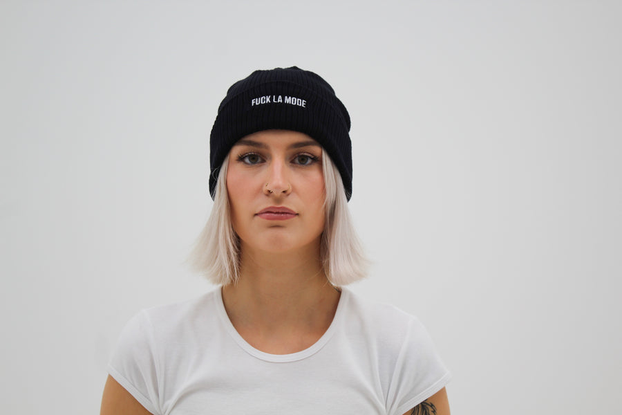 Black cotton beanie with the embroidered “fuck la mode” logo in white — streetwear clothing from Québec City.