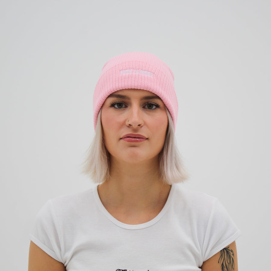 Light pink cotton beanie with the “fuck la mode” logo in white — streetwear clothing from Québec City.