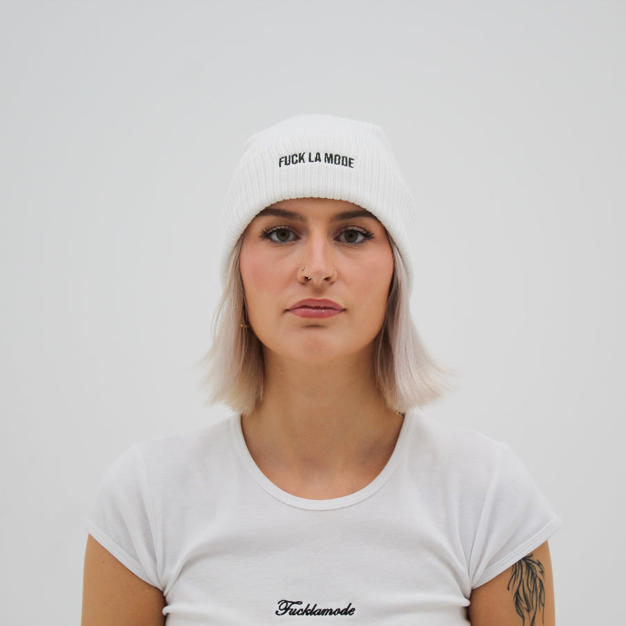 White cotton beanie with the embroidered “fuck la mode” logo in black — streetwear clothing from Québec City.