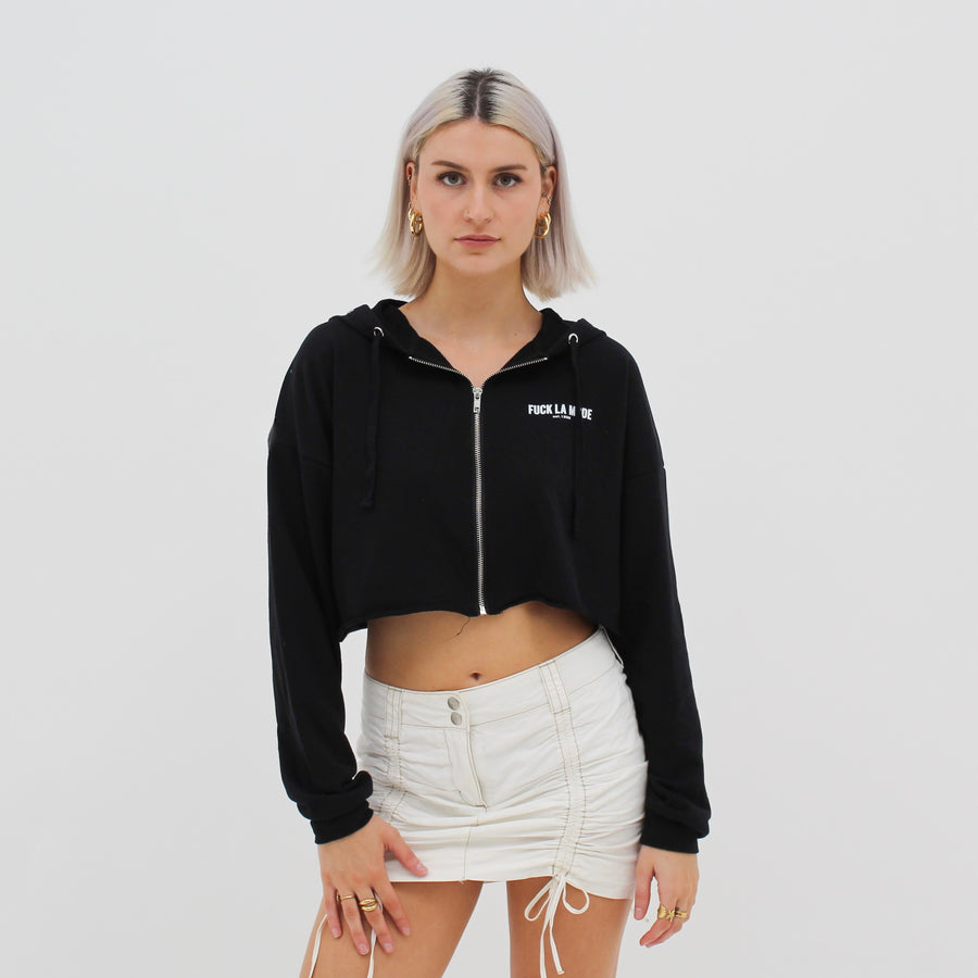 Black crop zip-up with the “fuck la mode” logo in white — streetwear clothing from Québec City.