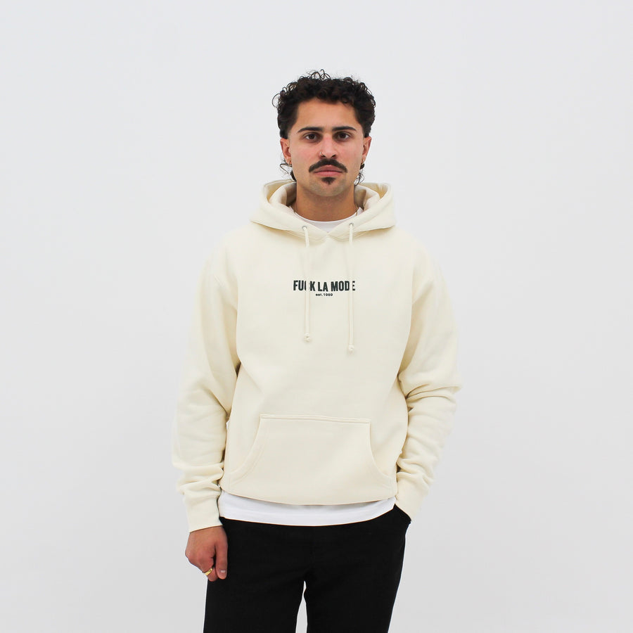 Cream heavyweight classic hoodie with the “fuck la mode” logo in black — streetwear clothing from Québec City.