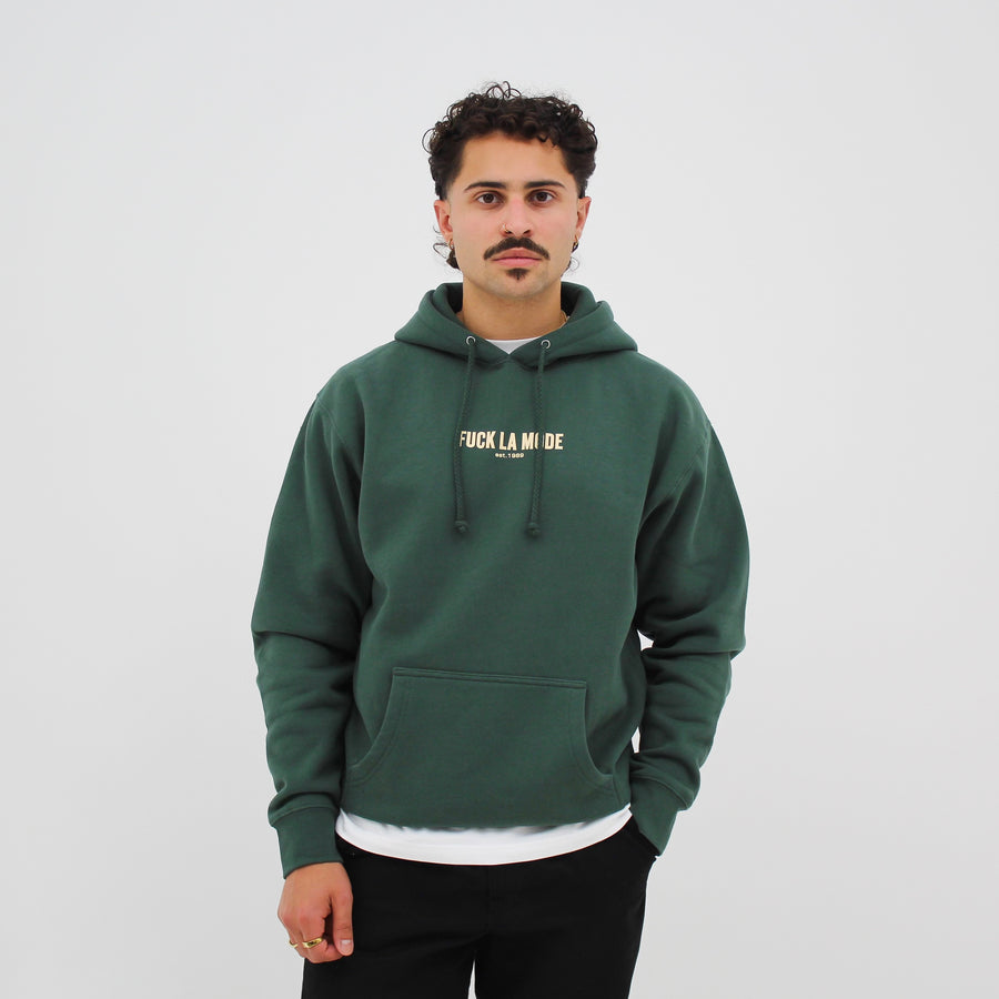 Green heavyweight classic hoodie with the “fuck la mode” logo in white — streetwear clothing from Québec City.