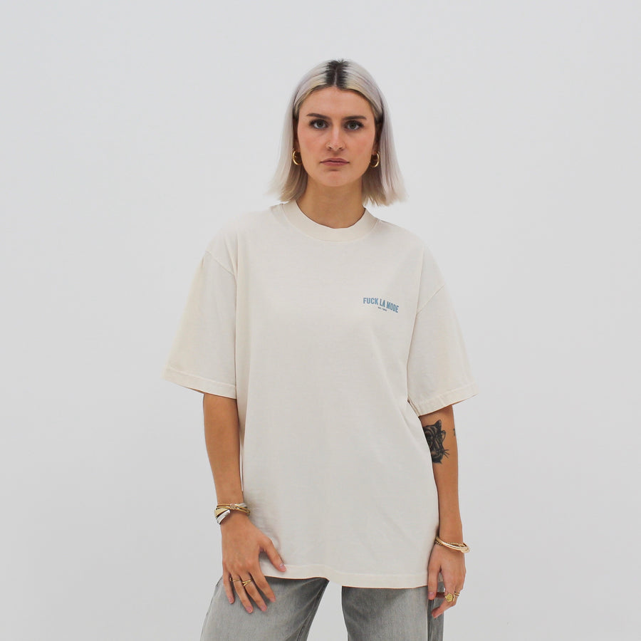 Cream oversized classic t-shirt with the “fuck la mode” logo in baby blue — streetwear clothing from Québec City.