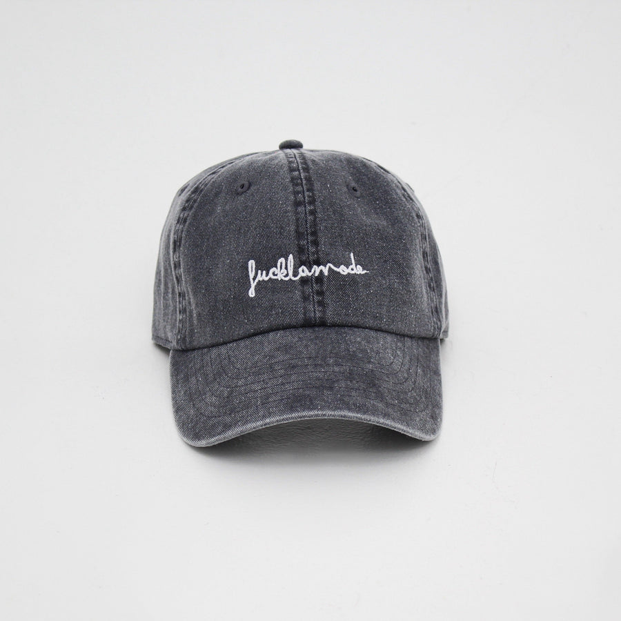 Vintage black pigment dye cap with the “fuck la mode” hand-written logo in white — streetwear clothing from Québec City.