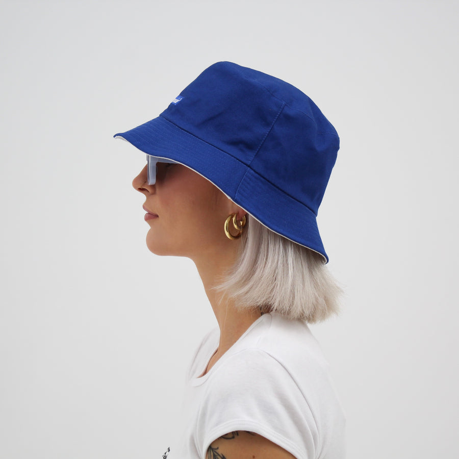 Reversible white and blue bucket hat with the “fuck la mode” logo — streetwear clothing from Québec City.
