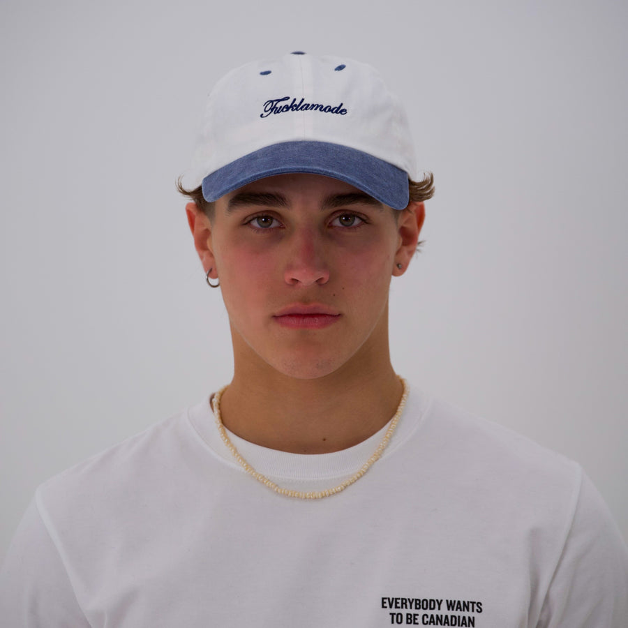Blue and white “fuck la mode” script cap — streetwear clothing from Québec City.
