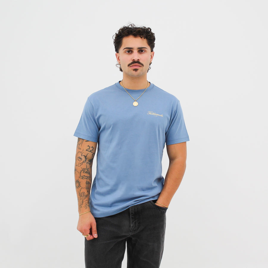 Baby blue “fuck la mode” t-shirt with the “fuck la mode” script logo — streetwear clothing from Québec City.