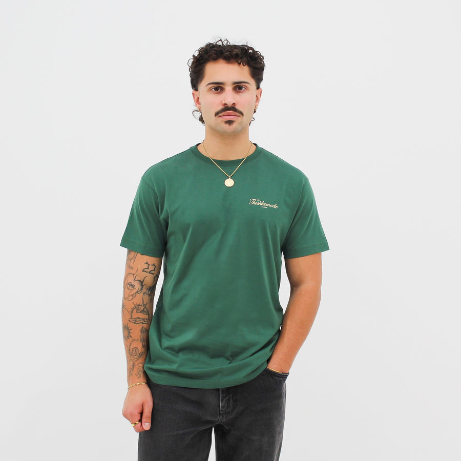 Green “fuck la mode” t-shirt with the “fuck la mode” script logo — streetwear clothing from Québec City.