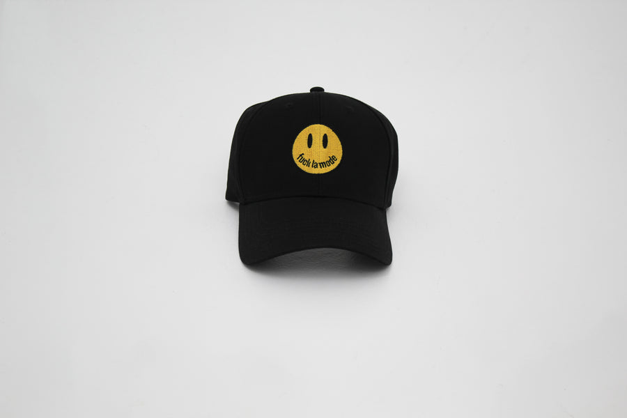 Black trucker hat with a yellow smiley face “fuck la mode” — streetwear clothing from Québec City.