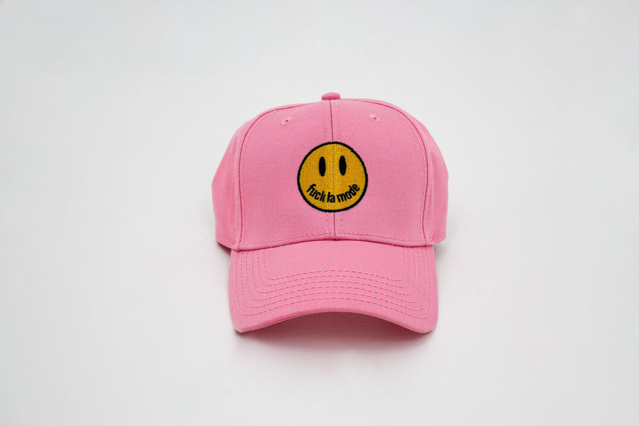 Pink trucker hat with a yellow smiley face “fuck la mode” — streetwear clothing from Québec City.