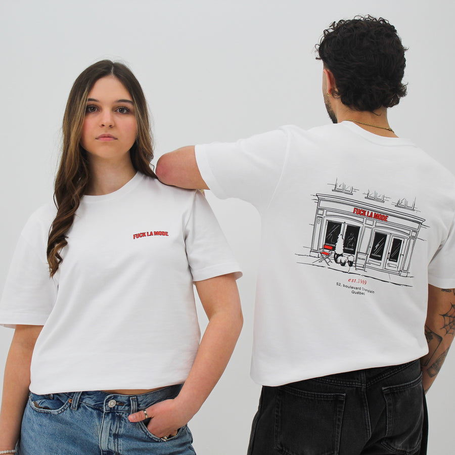 White t-shirt with black front store illustration and red “fuck la mode” logo — streetwear clothing from Québec City.