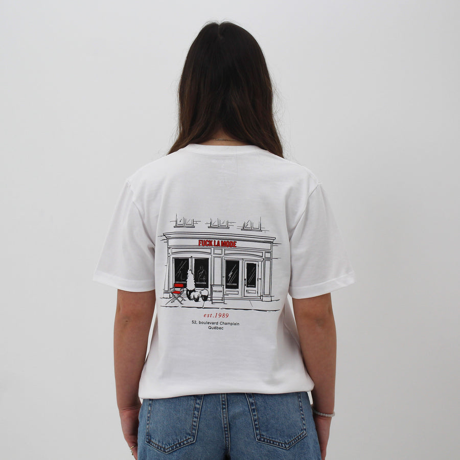 White t-shirt with black front store illustration and red “fuck la mode” logo — streetwear clothing from Québec City.