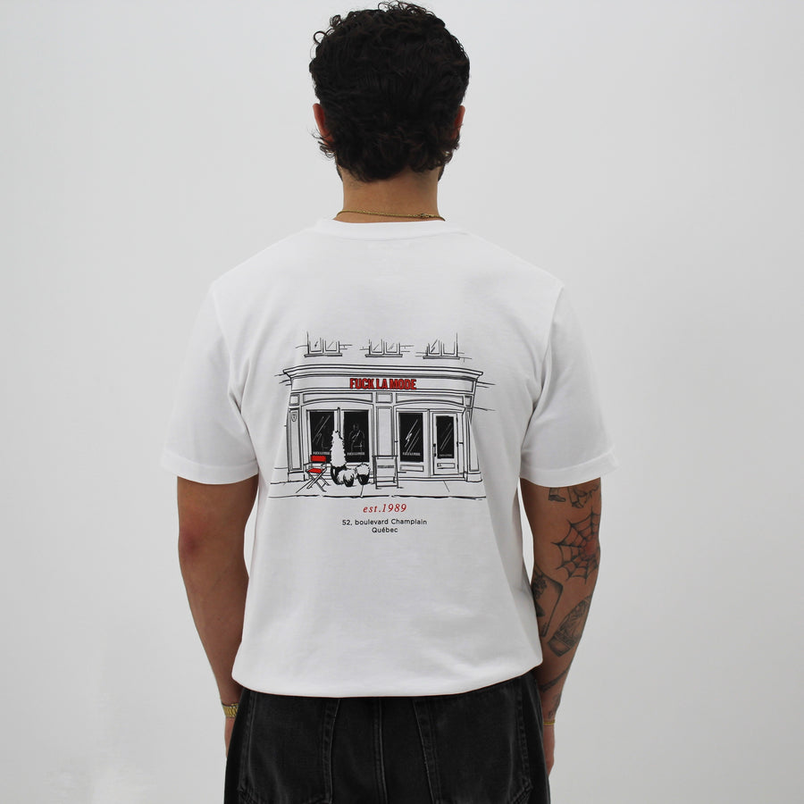 White t-shirt with black front store illustration and red “fuck la mode” logo — streetwear clothing from Québec City.
