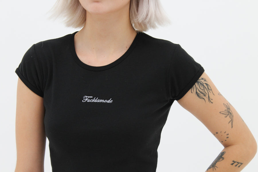 Black baby tee with the “fuck la mode” script logo on the front — streetwear clothing from Québec City.