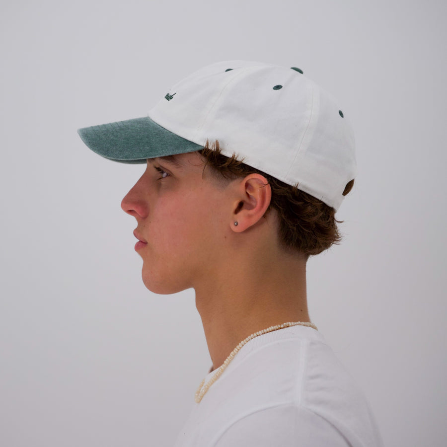 green and white “fuck la mode” script cap — streetwear clothing from Québec City.