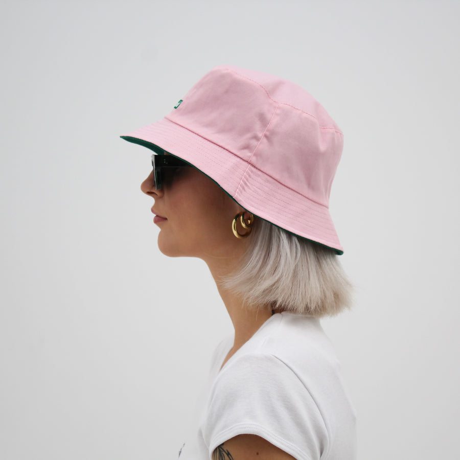 Reversible green and pink bucket hat with the “fuck la mode” logo — streetwear clothing from Québec City.