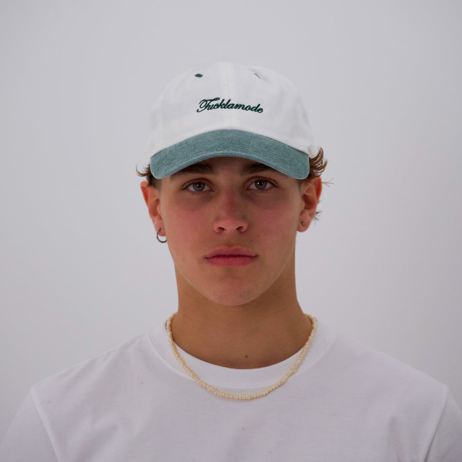 Green and white “fuck la mode” script cap — streetwear clothing from Québec City.