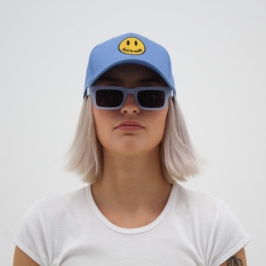 Blue trucker hat with a yellow smiley face “fuck la mode” — streetwear clothing from Québec City.