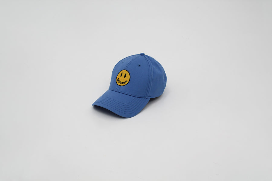 Blue trucker hat with a yellow smiley face “fuck la mode” — streetwear clothing from Québec City.