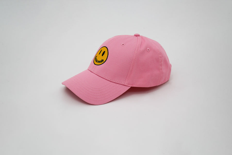 Pink trucker hat with a yellow smiley face “fuck la mode” — streetwear clothing from Québec City.