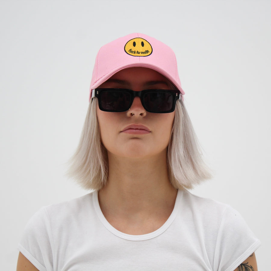 Pink trucker hat with a yellow smiley face “fuck la mode” — streetwear clothing from Québec City.
