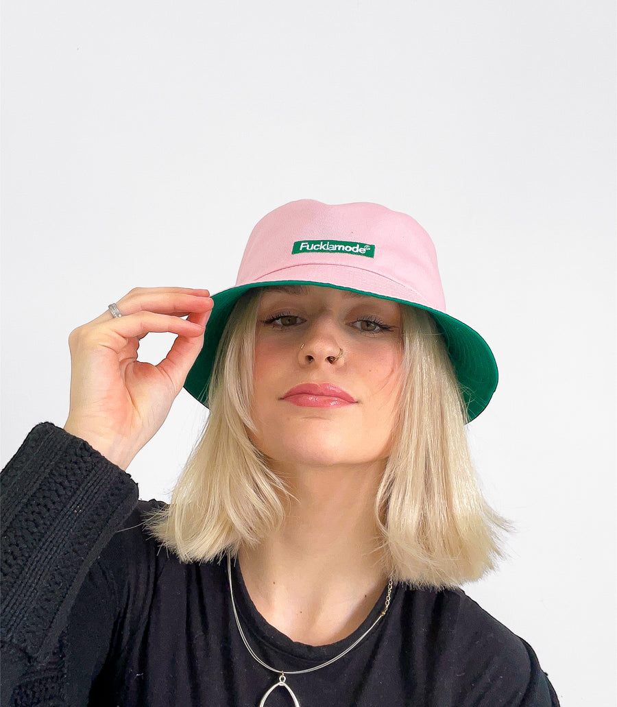Reversible green and pink bucket hat with the “fuck la mode” logo — streetwear clothing from Québec City.